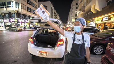 Beth Lopez offers motorists menus from Al Shater Hassan restaurant for a quick bite.