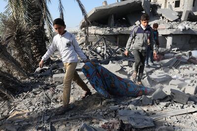 Palestinian children walk at the site of an Israeli strike on a house in Rafah, in southern Gaza, on December 22, 2023. Reuters