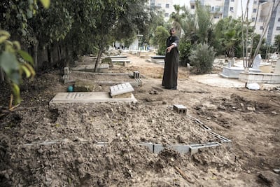 A Muslim cemetery care taker points to the fresh grave of of Diana Abu Qatifan, 18, that is marked marked by concrete construction blocks nearby the grave of her mother who was also killed and buried at the cemetery in Lod. Heidi Levine for The National