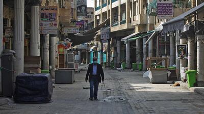 An Iraqi man walks past closed shops in Baghdad after authorities reimposed partial lockdown measures to slow the spread of the coronavirus. They will be in force until early March. AFP