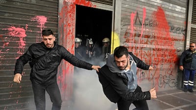 Striking tourism sector workers in Athens, Greece, flee tear gas fired by security forcers members at the entrance to the Ministry of Labour and Social Affairs. AFP