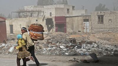 Syrians run for cover in Hamouria during Syrian government shelling on rebel-held areas in the Eastern Ghouta region on the outskirts of the capital Damascus on March 6, 2018. Abdulmonam Eassa / AFP