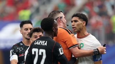 Morocco captain Achraf Hakimi clashes with Canada's Richie Laryea as referee Michael Oliver separates them. Reuters