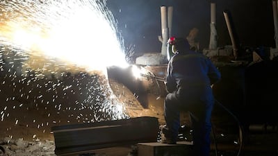 A ‘burner’ works on a piece of freshly cast steel as he works in the foundry at Sheffield Forgemasters. Oli Scarff / AFP