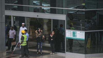 Workers clear the water to prevent flooding in front of the Abu Dhabi Mall. Mona Al Marzooqi / The National