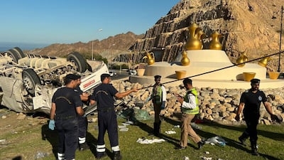 Rescuers and police officers at the accident scene, in Muscat