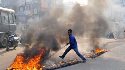 A demonstrator drags burning tyres during a day-long strike to protest against the killing of Sudip Datta Bhowmik, a local journalist, who according to local media was shot dead by a Tripura State Rifles trooper in Agartala, India. Jayanta Dey / Reuters