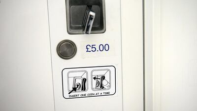 A passport photo booth accepts old one-pound coins. There are an estimated nearly £46 million forgeries in circulation. Bethany Clarke / Getty Images