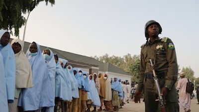 A soldier stands next to a group of girls previously kidnapped from their boarding school in northern Nigeria. AFP