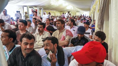 Workers wait to have their visa documents examined.