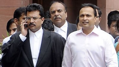 Reliance chairman Anil Ambani, right, walks with officials as he leaves the Supreme Court in New Delhi. RAVEENDRAN / AFP