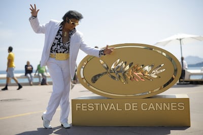 Elvis Presley impersonator Eryl Prayer poses on the Croisette near an installation of a Palme d'Or symbol ahead of the screening of the film 'Elvis' at the Cannes Film Festival on May 25. Reuters