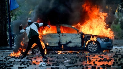 A protester throws a cobblestone during an anti-government demonstration in central Tirana, as protests continue over university conditions and demands for the resignation of Albanian Prime Minister Edi Rama. AFP