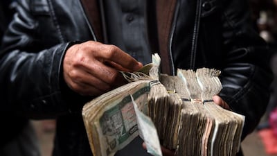 Afghan money changers count banknotes in the Sarayee Shahzada currency exchange market in Kabul on February 28,2017. Kidnappings and extortion have become a cottage industry, in Kabul, where even the appearance of wealth can be tantamount to a death sentence. Wakil Kohsar / AFP