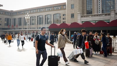 People arrive at the Beijing Railway Station on October 7. Chinese consumers travelled and spent less than expected over the Golden Week holiday. EPA