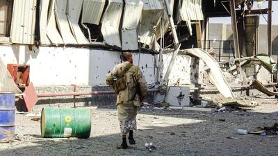 Members of the Yemeni pro-government forces walk through destruction in an industrial district in the eastern outskirts of the port city of Hodeida on November 18, 2018. AFP