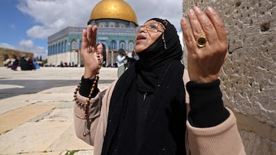 A woman offers first Friday noon prayers of Ramadan near the Dome of the Rock shrine, at the Al Aqsa Mosque compound, in the Old City of occupied East Jerusalem. AFP