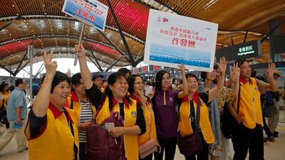 Tourists pose for a photograph at the departure hall in Hong Kong. AP Photo