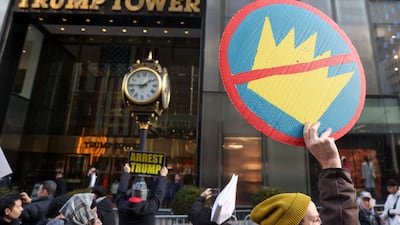 People hold placards in front of Trump Tower while marching during a 'No war, no kings, no Ice' protest in New York on Sunday. EPA