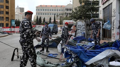 Lebanese security forces pull down tents as they clear away a protest camp and reopened roads blocked by demonstrators since protests against the governing elite started in October, in Beirut. REUTERS