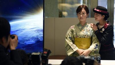 A reception clerk poses with Toshiba’s humanoid robot ChihiraAico. FRANCK ROBICHON / EPA