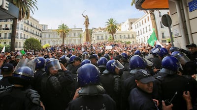 Police officers stand guard as demonstrators carry banners and flags during a protest against the country's ruling elite and rejecting a December presidential election in Algiers, Algeria. Reuters