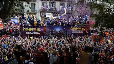 Barcelona players ride on the team bus during celebrations in Barcelona, Spain Sunday June 7, 2015 after winning the Champions League final soccer match Saturday by beating Juventus Turin 3-1. Barcelona won the triple this season winning the Spanish League title, the Copa del Rey and the Champions League. (AP Photo/Emilio Morenatti)