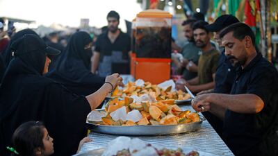 Men distribute fruits to Shiite Muslim pilgrims marching from Baghdad towards the shrine city of Karbala.