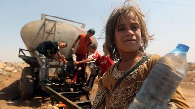 Young Yazidi refugees collect water at a refugee camp in Hasaka province in north eastern Syria. They were forced to flee Iraq along with Christians after Islamic State militants captured their towns. Ahmad Al Rubaye / AFP / August 14, 2014