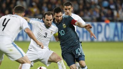 Argentina's Lionel Messi fights for the ball with Uruguay defender Diego Godin. AFP