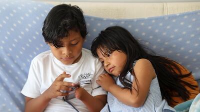 Juan uses a mobile phone next to his sister Ana at their home in Parla. Reuters