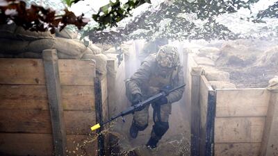 A soldier runs through trenches