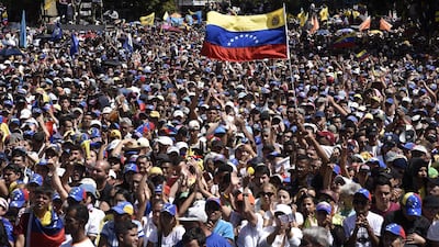 Demonstrators wave Venezuelan flags while listening to Juan Guaido, president of the National Assembly. Bloomberg