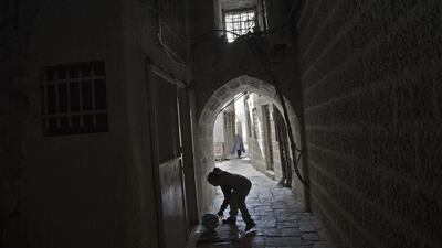 A young boy from the African Muslim community plays with a ball at the entrance to one of the detached housing complexes, called a hoash, near the Al Aqsa Mosque in the Old City.