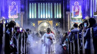 A priest attends Christmas Mass at Saint Antuan Church in the Beyoglu district of Istanbul on December 24, 2017. Yasin Akgul / AFP