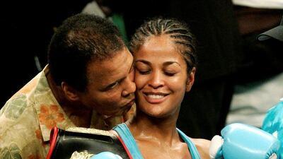 WBC and WIBA super middleweight champion Laila Ali is kissed by her father, boxing great Muhammad Ali, at the MCI Center in Washington in this June 11, 2005 file photo. Jason Reed / Reuters