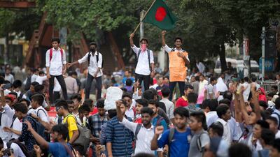 A Bangladeshi student waves the national flag and shouts slogans as they block a road during a protest in Dhaka, Bangladesh. AP Photo / A. M. Ahad