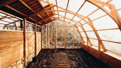 The wall performs as a thermal insulator for the greenhouse, absorbing heat during the day and releasing it at night