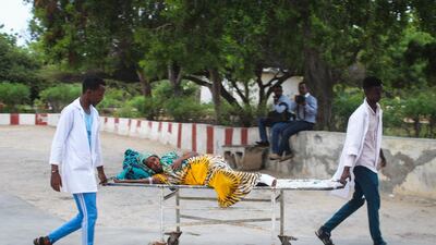 Medics carry a woman who was injured in a blast on a stretcher at Medina hospital in Mogadishu, Somalia, 24 July 2019. EPA
