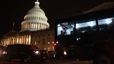 The legal defence team for US President Donald Trump is loaded on a bus on Capitol Hill in Washington on Friday. AP Photo