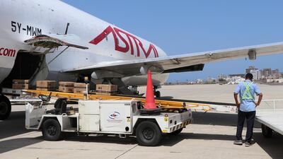 An airport worker unloads boxes containing coronavirus vaccines at the airport in Aden, Yemen. AP Photo