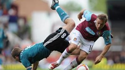 The Liverpool captain Steven Gerrard falls over West Ham's Mark Noble as they battle for the ball at Upton Park. Gerrard's two goals helped the Reds to a 3-0 win which took them back to the top of the Premier League.