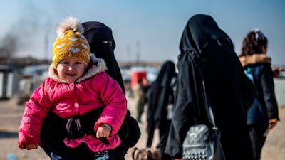 A woman, suspected of being related to ISIS fighters, holds a child in the Kurdish-run Al Hol camp in Syria. AFP