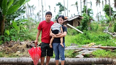 Aiza Tonida and husband Jericho Caga with their son Jaizen Jericho Caga at the site of their totally destroyed house in Barangay Salvador, Tanauan. (Joey Reyna for The National / April 9, 2014)