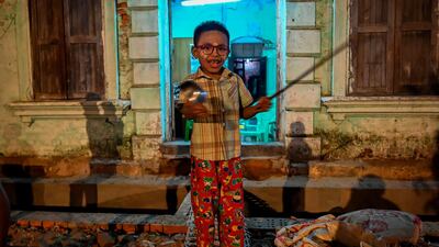 A child hits a plate with a pair of scissors to make noise after calls for protest went out on social media in Yangon. AFP