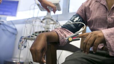 Complaining of abdominal pain, Robel Rahman, an electrician from Bangladesh, is having his vitals checked as he is examined at the emergency department of Burjeel Hospital. Silvia Razgova / The National