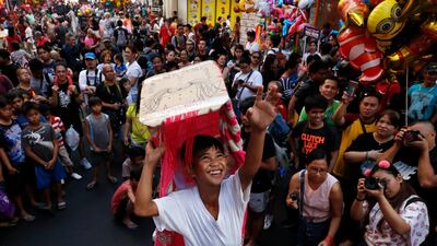 Filipino children perform with dragon costumes in front of revellers in Manila's Chinatown. Francis R Malasig / EPA