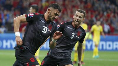 Albania's Armando Sadiku, left, celebrates after scoring to give his team the lead just before half time. Kai Pfaffenbach / Reuters