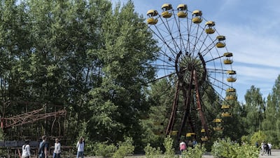 Tourists take pictures at a rusty ferris wheel, one of the most famous landmarks in Pripyat. Getty Images