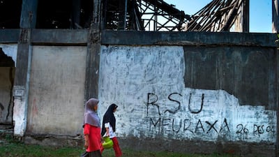 Women walk by a building dedicated to the 2004 Indian Ocean earthquake and tsunami that killed more than 220,000 ahead of the 15th anniversary on December 26, in Banda Aceh. AFP